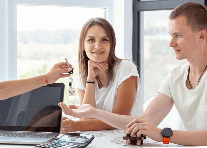 front-view-couple-accepting-keys-their-new-house(2)